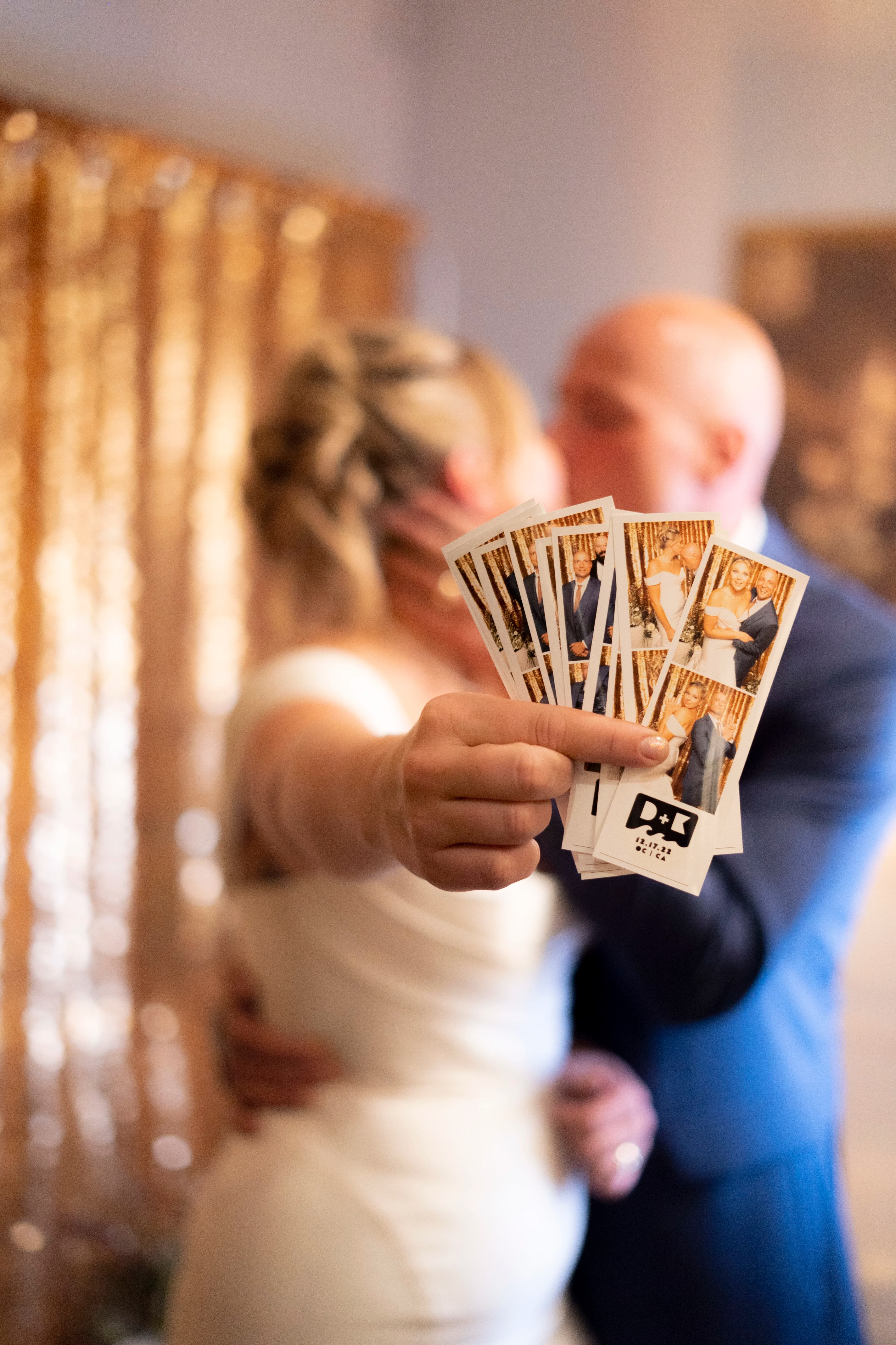 couple kissing in background with photo strips in focus